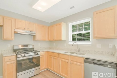 A kitchen with wooden cabinets and a stainless steel oven.