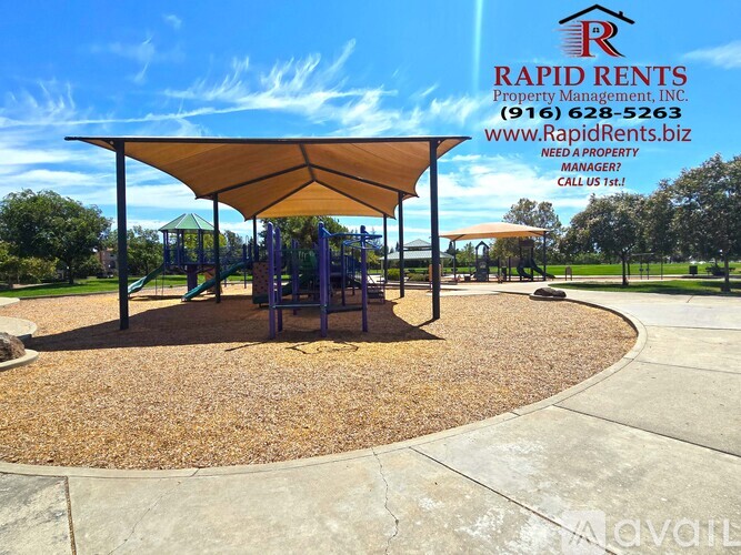A playground with a swing set and a canopy is shown with an advertisement for Rapid Rents Property Management, Inc. in the background.