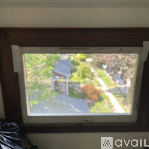 A window with a view of a house and trees outside.