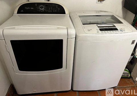 Two white appliances, a microwave and a dryer, are on a kitchen counter.
