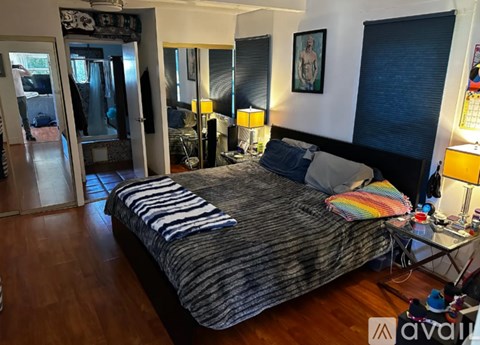 A bedroom with a bed, nightstand, and lamp.