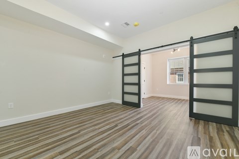 A room with wooden flooring and a sliding door.