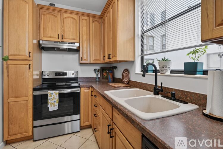 A kitchen with wooden cabinets and a stainless steel oven.