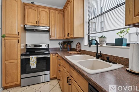 A kitchen with wooden cabinets and a stainless steel oven.