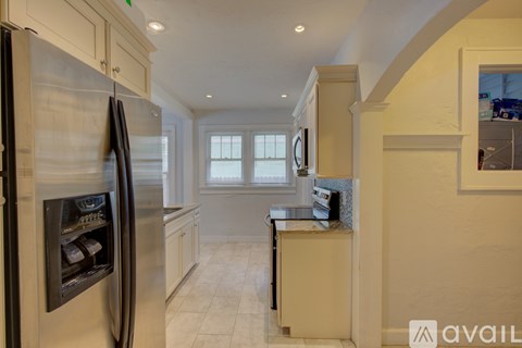 A kitchen with a stainless steel refrigerator and a countertop with a sink.