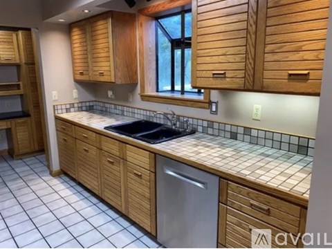 A kitchen with wooden cabinets and a tiled backsplash.