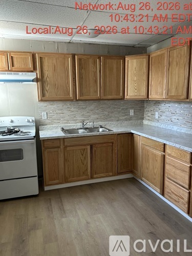 A kitchen with wooden cabinets and a white stove top oven.