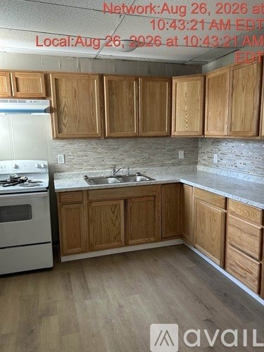 A kitchen with wooden cabinets and a white stove top oven.