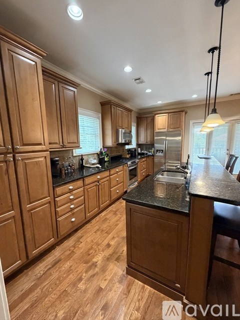 A kitchen with wooden cabinets and black countertops.