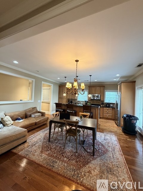 A well-lit living room with a dining table and chairs.