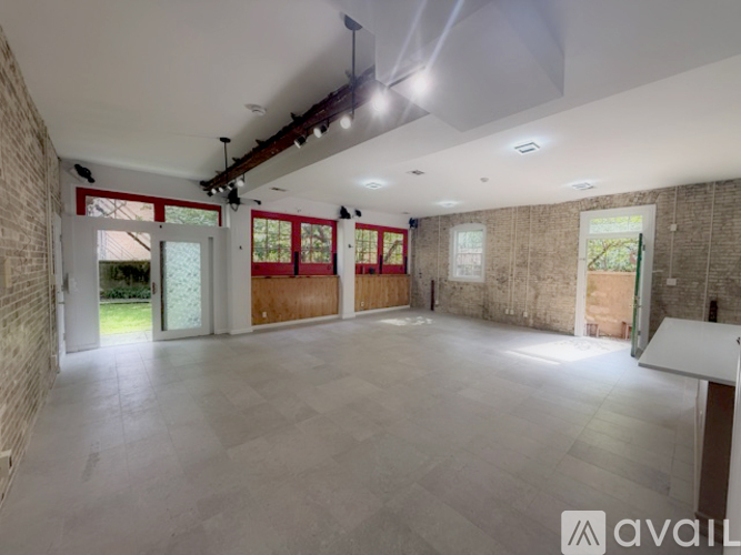 A spacious room with a brick wall and a tiled floor.