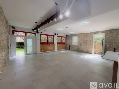 A spacious room with a brick wall and a tiled floor.