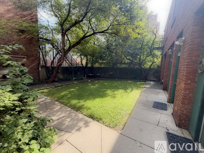 A backyard with a tree and a brick building.