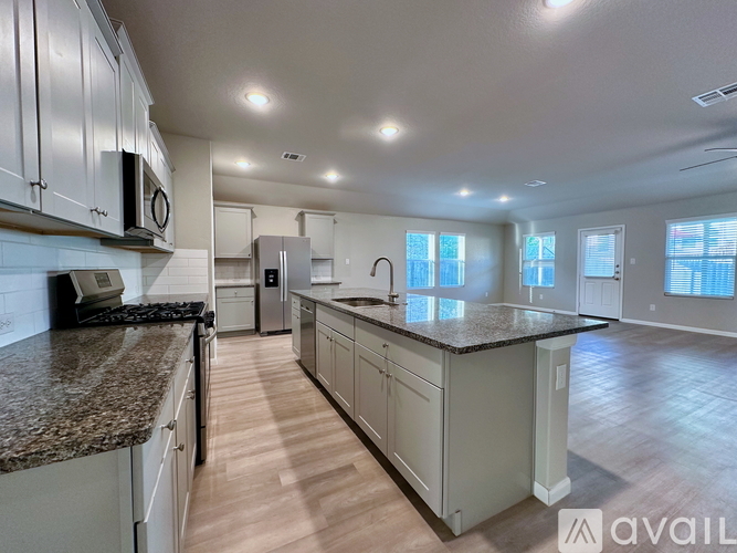 A kitchen with granite countertops and white cabinets is available for rent.