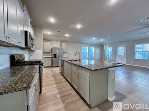 A kitchen with granite countertops and white cabinets is available for rent.