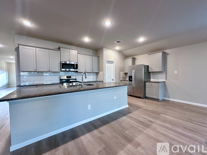 A kitchen with a granite countertop and stainless steel appliances.