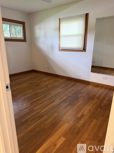 A room with wooden flooring and a window.
