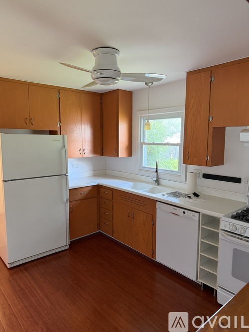 A kitchen with wooden cabinets and a white refrigerator.