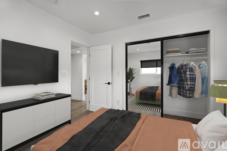 A bedroom with a bed, a television, and a wardrobe.