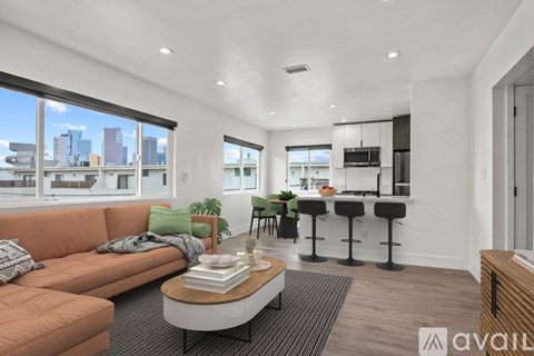 A living room with a couch, a table, and a bar area.