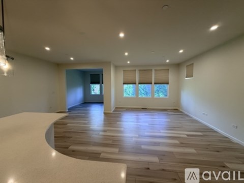 A spacious room with wooden flooring and a curved wall.