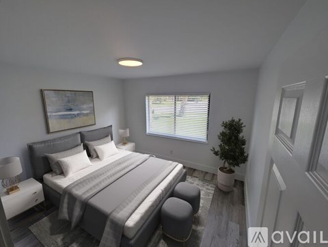 A bedroom with a large bed and a small potted plant by the window.