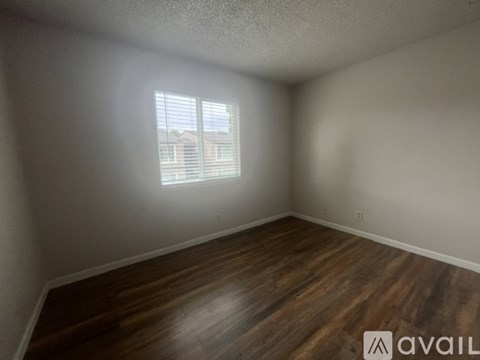 Empty room with wooden flooring and a window.