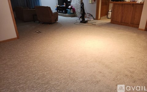 A room with a carpeted floor and a large window.