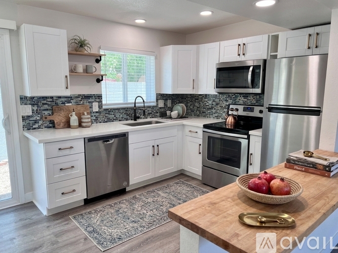 A kitchen with white cabinets and a wooden island.