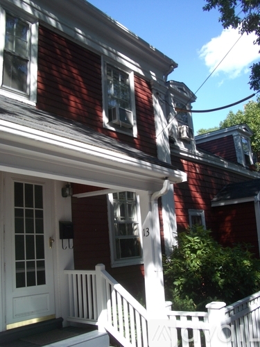 A red house with a white porch and a white door.