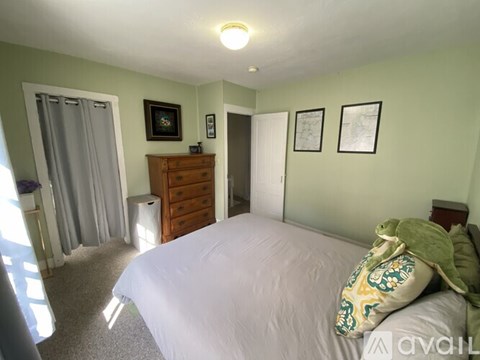 A bedroom with a bed, dresser, and two pictures on the wall.