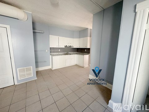 A Vodock Apartments sign is on a wall in a kitchen.