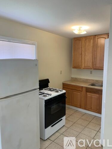 A kitchen with a white refrigerator and a white stove top oven.