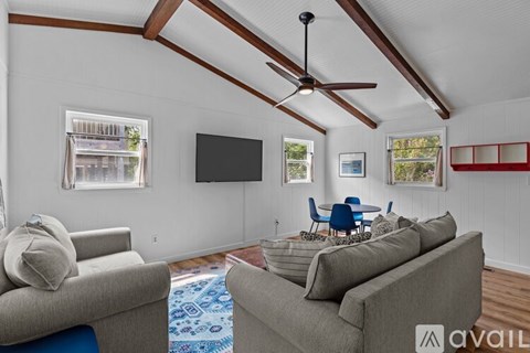 A living room with a grey couch and a blue rug.