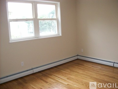 A room with a window and wooden flooring.