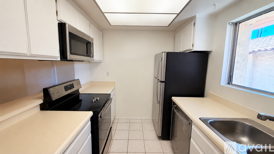 A kitchen with black appliances and white cabinets.