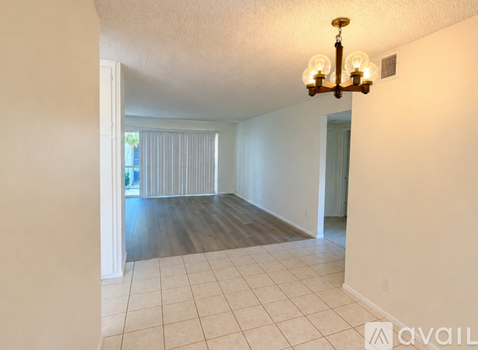 A room with a chandelier and a tiled floor.