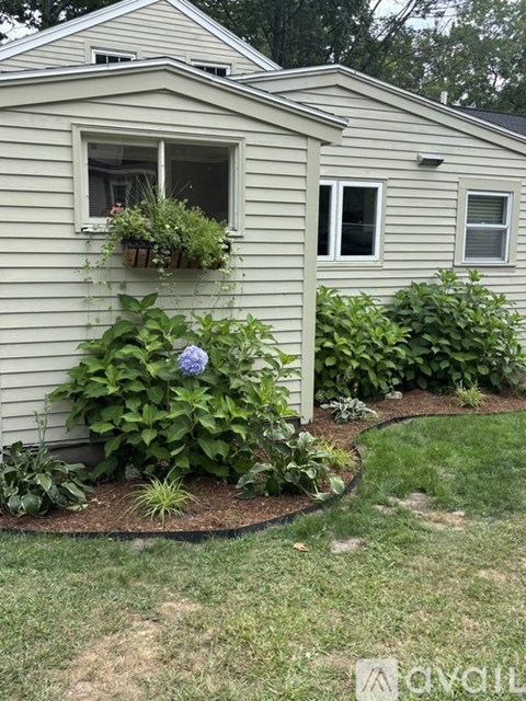 A house with a grey siding and a window box with plants.