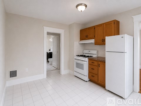 A kitchen with white appliances and wooden cabinets.