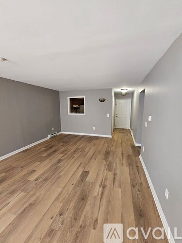 A room with wooden flooring and a white ceiling.