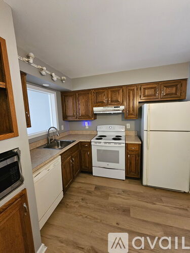 A kitchen with wooden cabinets and white appliances.
