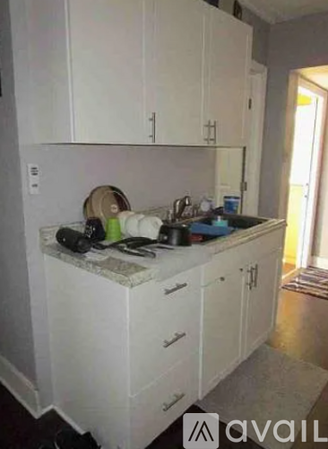 A kitchen with white cabinets and a marble countertop.