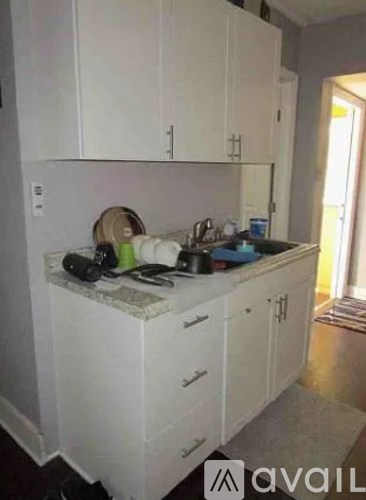 A kitchen with white cabinets and a marble countertop.