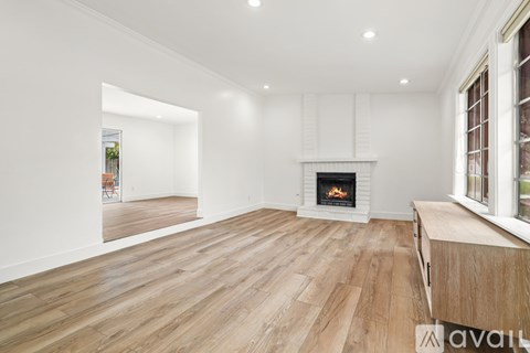 A spacious living room with a fireplace and wooden flooring.