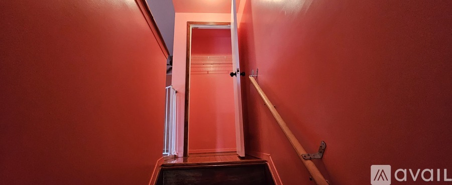 A hallway with red walls and a wooden floor.