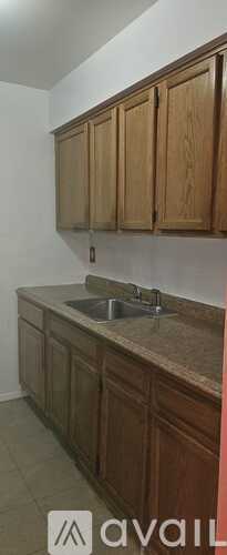 A kitchen with wooden cabinets and a granite countertop.