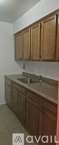 A kitchen with wooden cabinets and a granite countertop.
