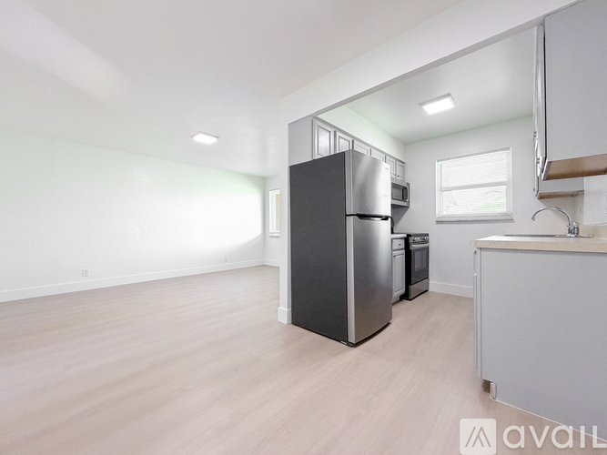 A kitchen with a black fridge and a white counter.