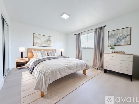 A bedroom with a large bed, a nightstand, and a dresser.