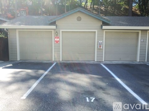 A parking lot with a building and a number 17 painted on the ground.